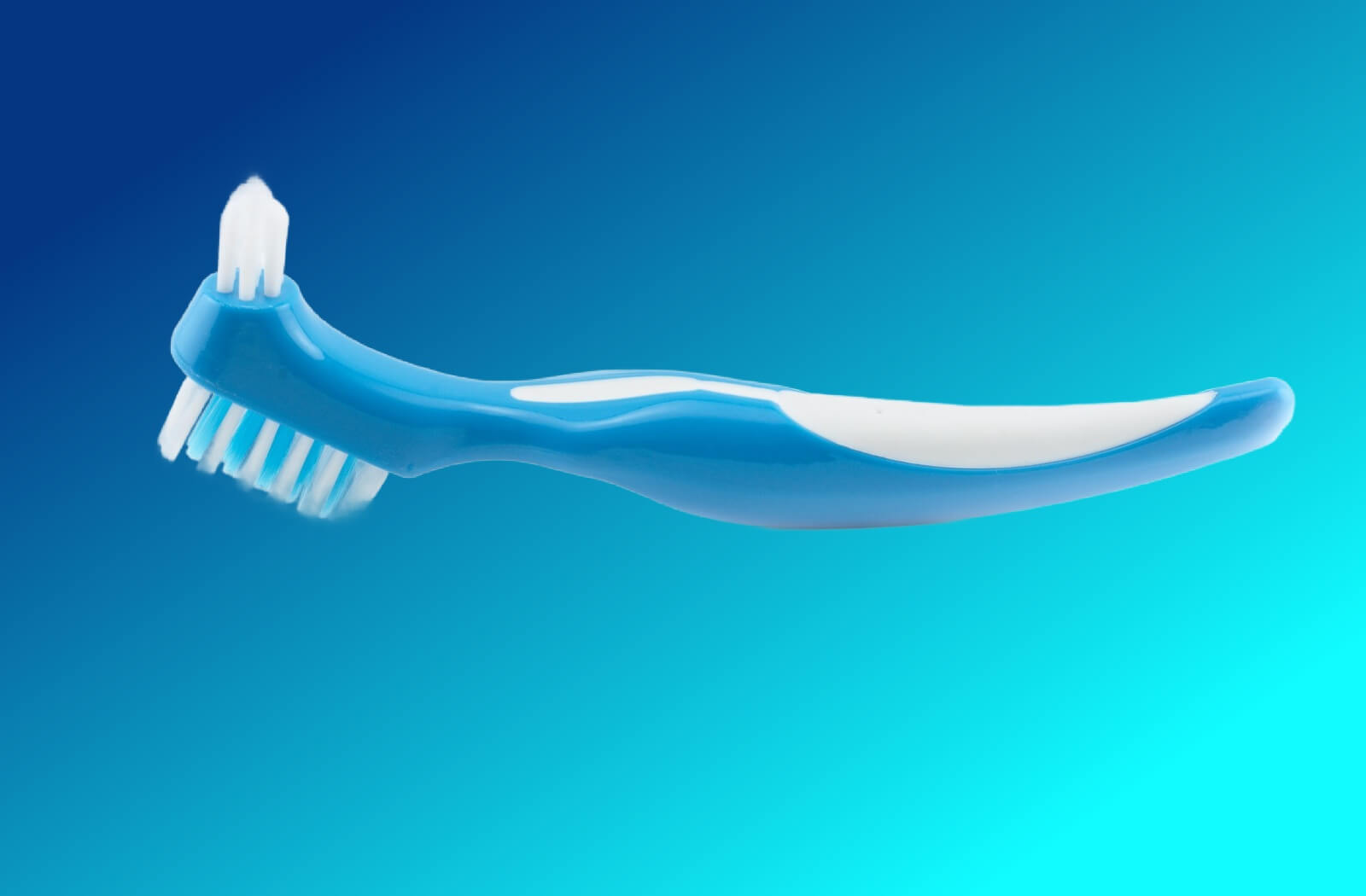 A denture brush on a blue background.