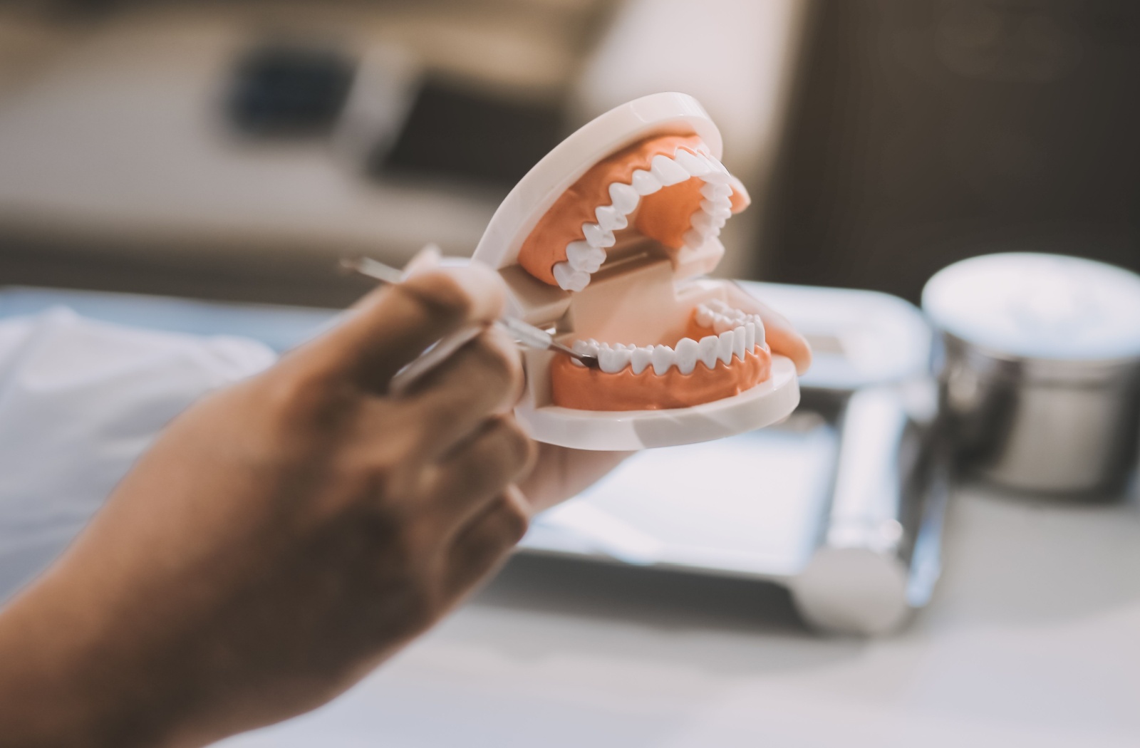 A dentist's hands holding a set of dentures.