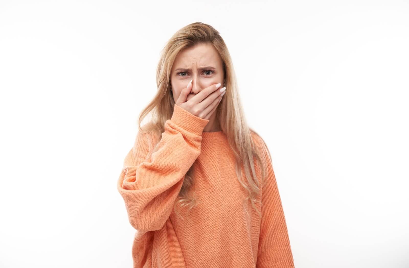 A woman covers her mouth, embarrassed about her missing tooth.